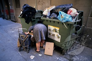 An old woman digs through trash in the El Raval quarter of Barcelona.