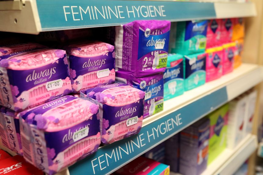 Pink menstrual pad packaging and a store shelf labelled "feminine hygiene." Ouch!