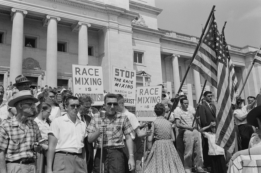 A black-and-white photo of racists protesting against desegregation