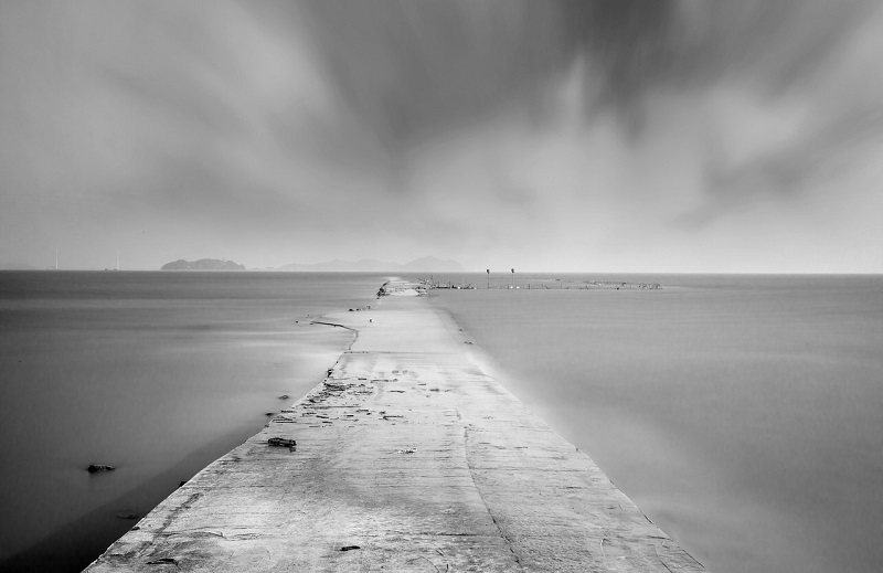 A misty path surrounded by water on both sides