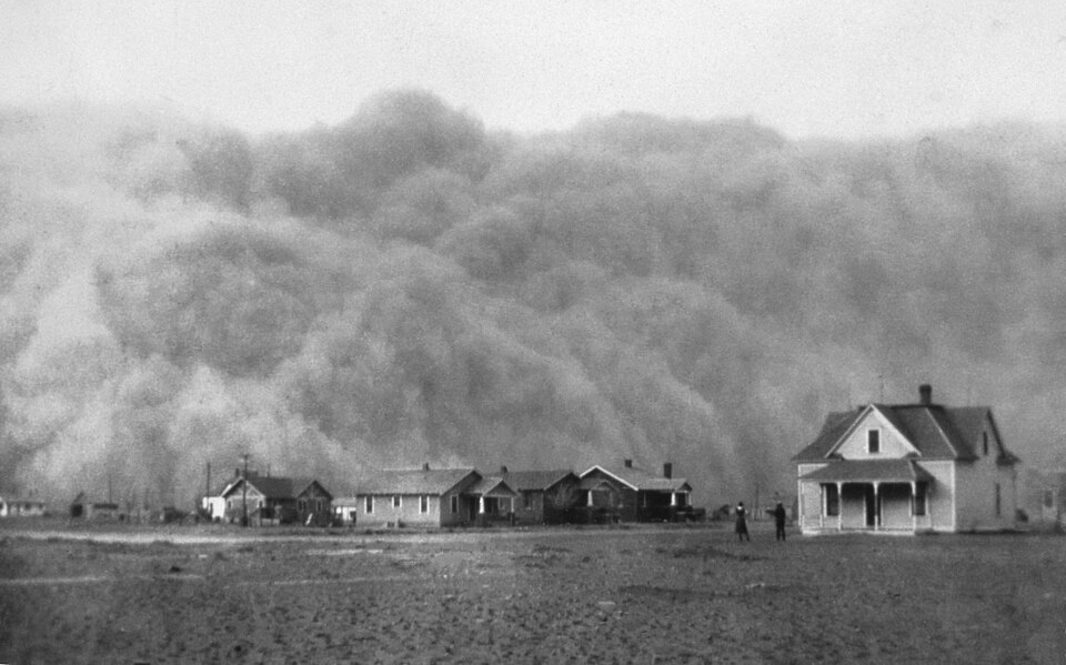 A huge cloud of dust about to engulf a farm