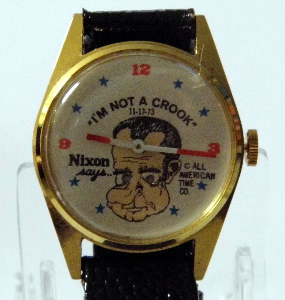A novelty watch with Richard Nixon's face and the text 'Nixon says: I'm not a crook'