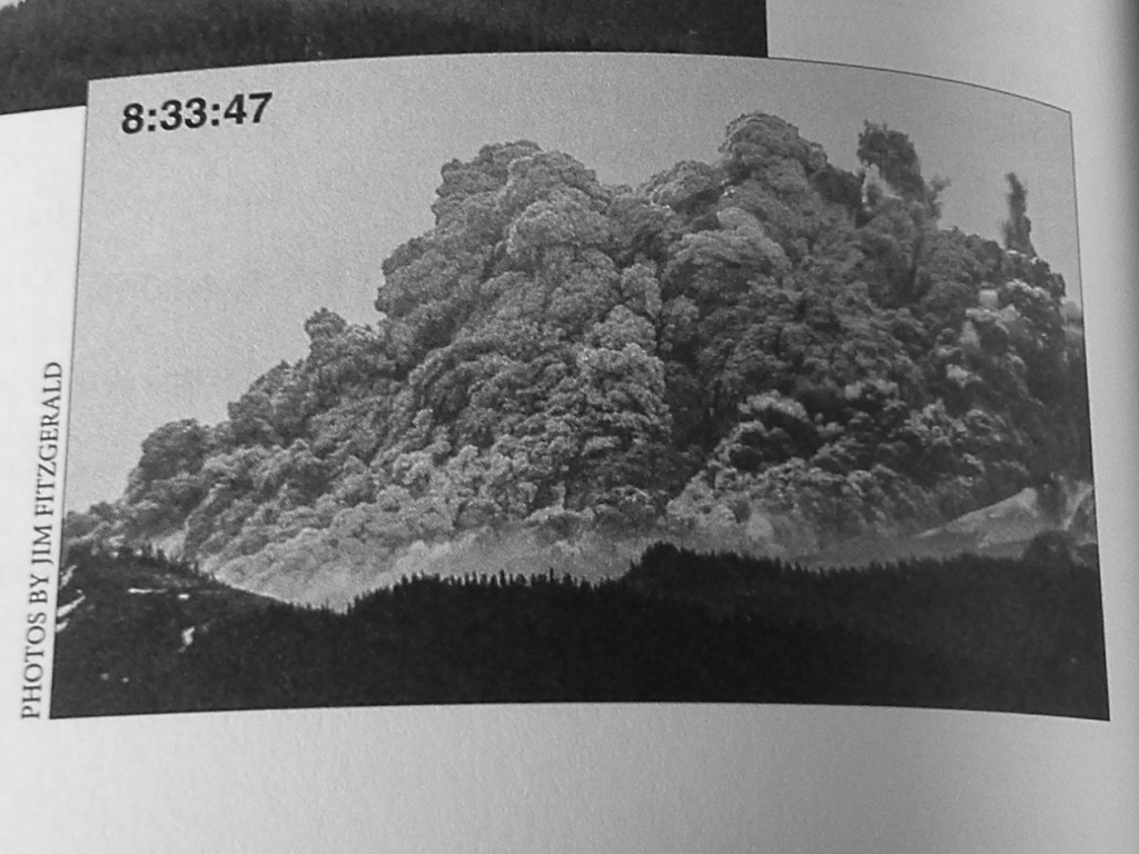 Image shows a huge eruption cloud swallowing Mount St. Helens. Image marked as taken at 8:33:47 am