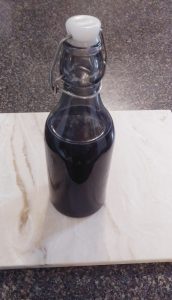 A capped unmarked bottle containing a purple-blue liquid.
