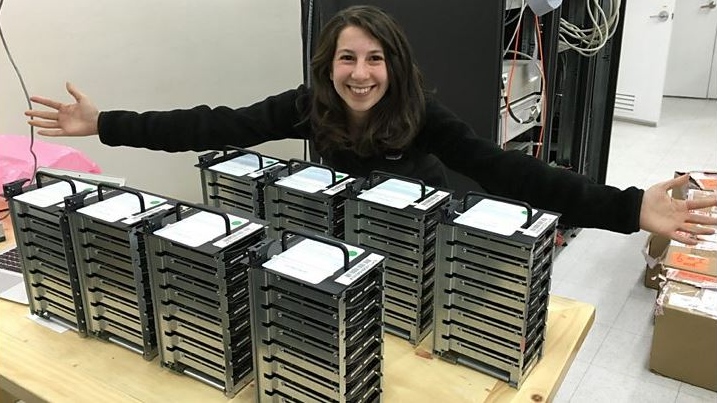 Dr. Katie Bouman, in front of a stack of hard drives.